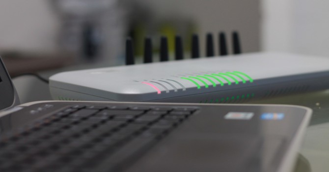 En router eller ett modem blinkar bredvid en laptop