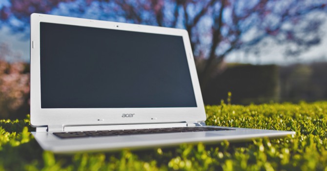Bärbar dator från Acer med WiFi på gräsmattan. Det kan vara konstgräs.