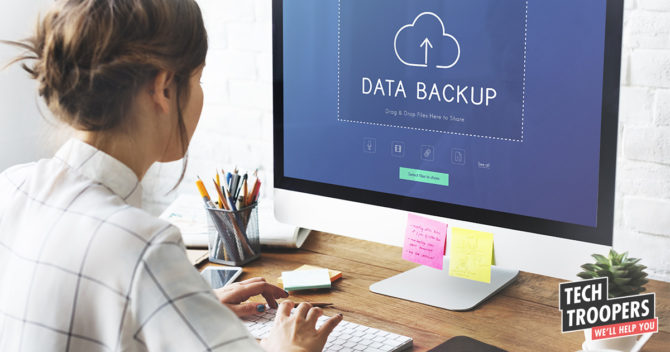 women sitting with laptop making a backup
